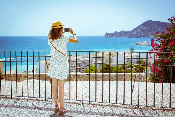 Chica turística tomando una foto con un smartphone del mar Mediterráneo en Altea, Alicante, España — Foto de Stock