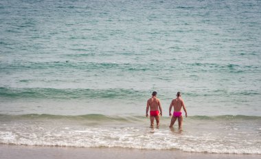 Sitges, İspanya, Eylül 2018. Eşcinsel çift tatilde plajda