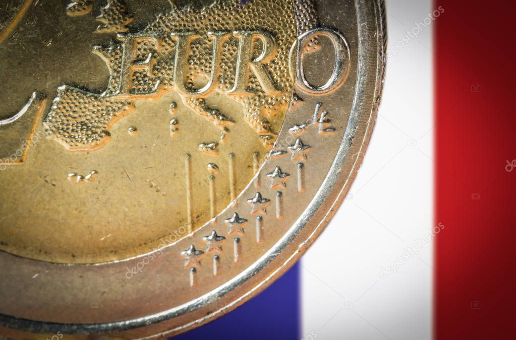 2 Euro coin with a blurred flag of France on the background.