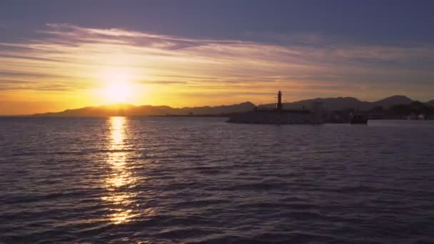 Hora del atardecer y faro del puerto en el pueblo pesquero mediterráneo de Cambrils, España — Vídeo de stock