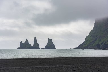 Bazalt kaya oluşumları veya siyah beach uçlarında Troll. Reynisdrangar, Vik, İzlanda