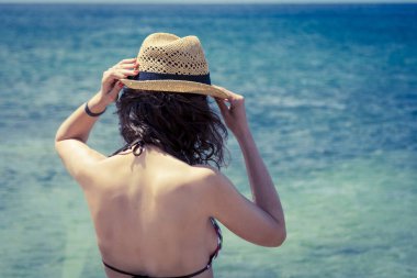 Güzel kadın sunhat ve bikini sahilde sıcak yaz gününde arıyorum. Fuerteventura Adası, İspanya'dan fotoğraf