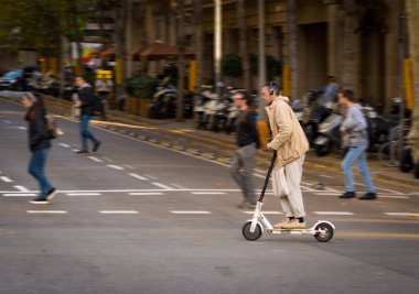 Bir kişi bir sokakta Barselona elektrikli scooter üzerinde.