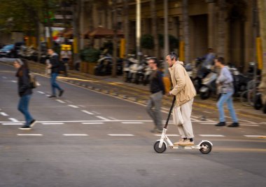 A person on electric scooter in a street of Barcelona. clipart