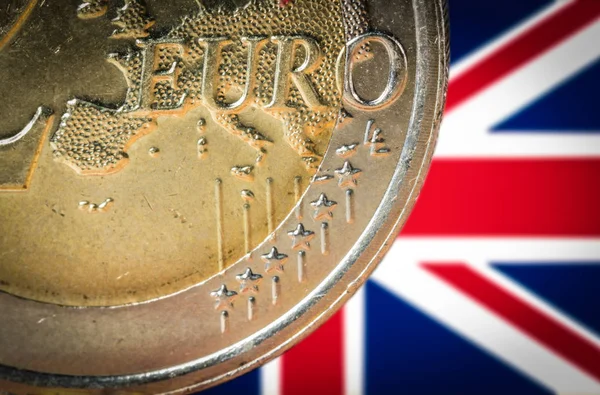 2 євро монетою з розмитими прапор Великобританії на тлі — стокове фото