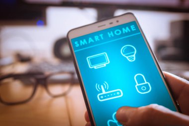 Akıllı ev teknolojisi arabirimi aygıtı tutan kişi akıllı telefon app ekranda