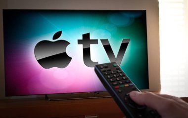Barcelona, İspanya. Ocak 2019: Adam bir uzaktan kumanda ile Apple Tv simgesi ekran televizyonda tutar