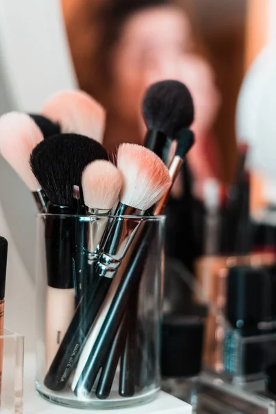 Reflektion av ung vacker kvinna tillämpa hennes make-up, titta i en spegel — Stockfoto