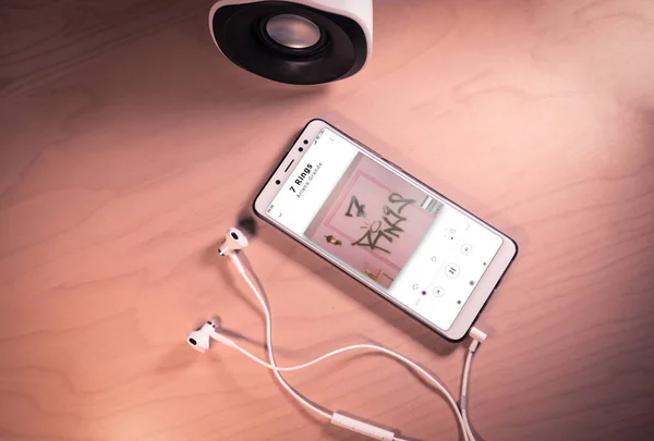 Top view image of smartphone,earphones and speaker with Ariana Grande song on screen — Stock Photo, Image