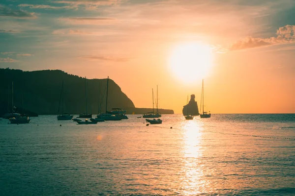 Sailboats in a harbor at sunset in cala benirras. Mediterranean sea of Ibiza island — Stock Photo, Image