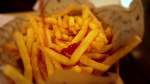 Despejando molho de tomate sobre batatas fritas. Fast food popular, batatas fritas fritas fritas . — Vídeo de Stock