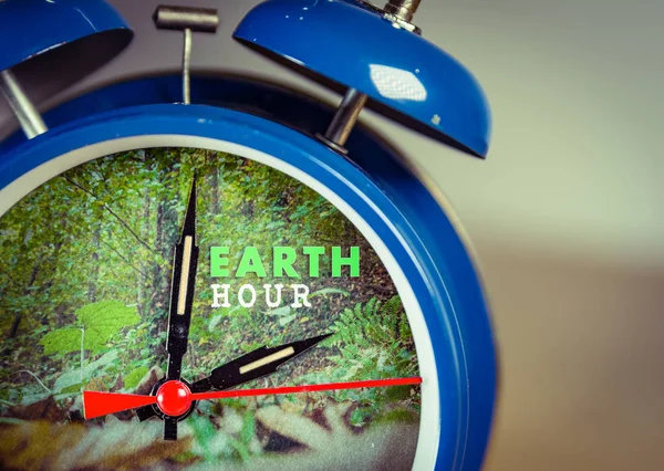 Ceas cu alarmă retro cu fundal natural care simbolizează ora Pământului — Fotografie, imagine de stoc