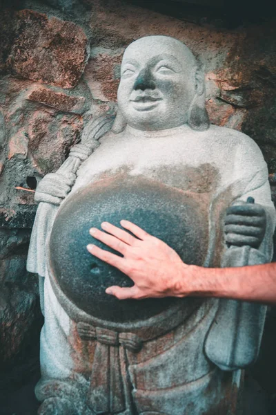 Main touchant le ventre d'une statue de bouddha riante dans le temple bouddhiste Yonggungsa à Busan, Corée du Sud — Photo