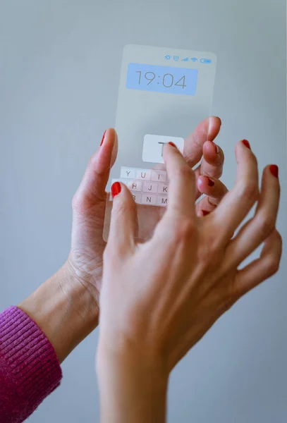 Mujer de mano sosteniendo el teléfono inteligente transparente y tocando la pantalla —  Fotos de Stock