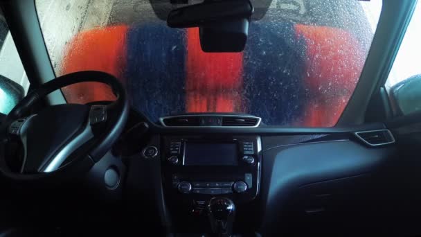 Vista interior de un coche que se lava en una máquina automática. Lavado de coches desde el interior del coche. — Vídeos de Stock