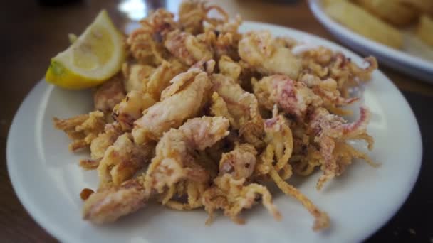 Spanische Tapas: Teller mit frittierten Tintenfischen oder Chipirones mit Zitrone. — Stockvideo