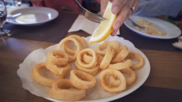 Spanish tapas: Plate of Roman-style squid or fried calamari with lemon. — Stock Video
