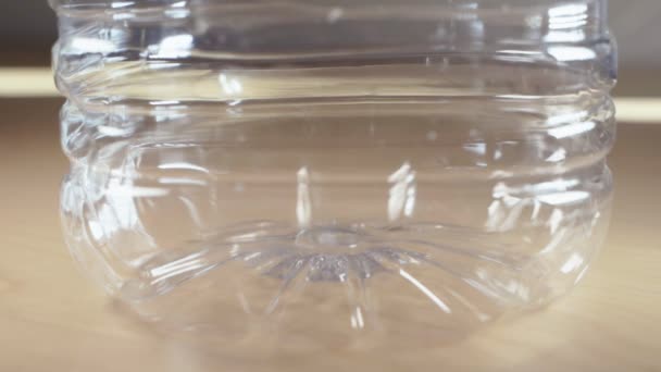 Kleine Weltkugeln, die in eine Plastikwasserflasche fallen — Stockvideo