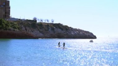 Yaz tatilinde raket tahtası çift paddleboarding ayağa kalk.