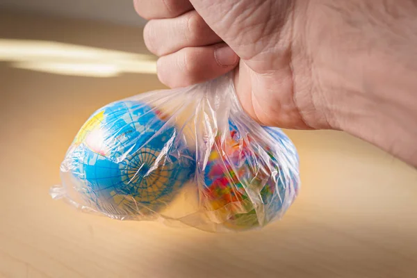 Putting small world globes inside a plastic bag