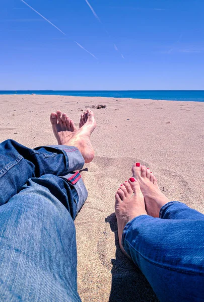 Wakacje. Mężczyzna i kobieta stopy zbliżenie na plaży na solarium korzystających słońce w słoneczny letni dzień. — Zdjęcie stockowe