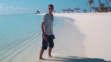 Yakışıklı adam beyaz kıyafetlerle deniz sahne poz