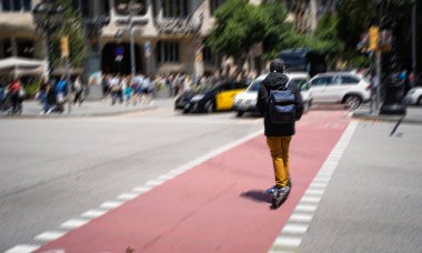 Bir kişi bir sokakta Barselona elektrikli scooter üzerinde.