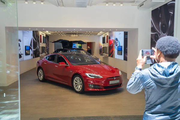 Barcelona, Espanha. Junho de 2019: Pedestre tirando uma foto com o smartphone fora de uma loja Tesla — Fotografia de Stock