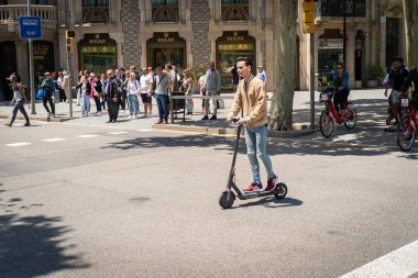 Bir kişi bir sokakta Barselona elektrikli scooter üzerinde.