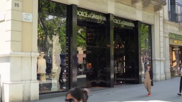Barcelona, Spain. June 2019: People walking in front of Dolce Gabbana shop — Stock Video