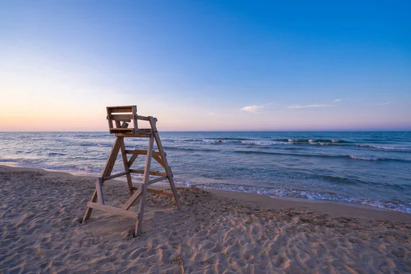 Beach with wooden lifeguard chair in sunset time. — Stock Photo, Image