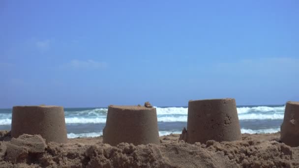 Closeup pískových hradů na písku na pláži — Stock video