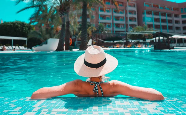 Kobieta z Kapelusz przeciwsłoneczny relaks w basenie w Spa Resort. — Zdjęcie stockowe