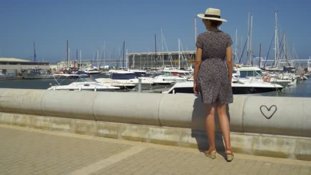 Touristin mit Strohsonnenhut im Hafen von Denia Marina, Alicante, Spanien