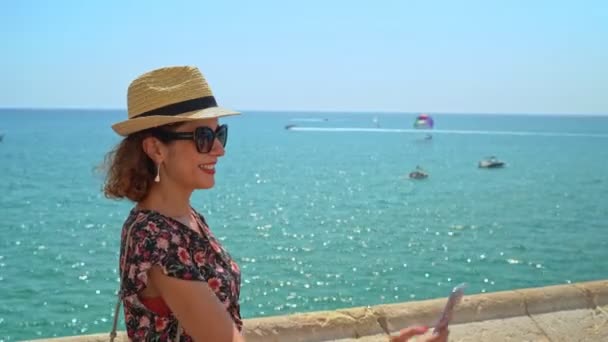 Selfie çeken, yüz yüze fotoğraf çeken ya da arka planda Akdeniz ile fotoğraf çeken kadın — Stok video