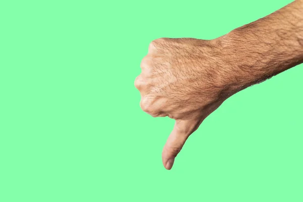 Thumb down hand sign isolated on a green background