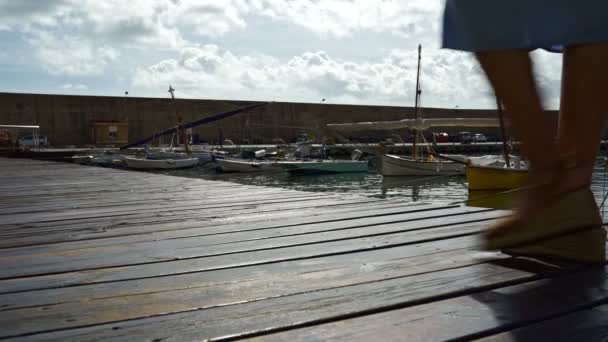 Piernas de mujer caminando en la pasarela de madera del muelle — Vídeo de stock