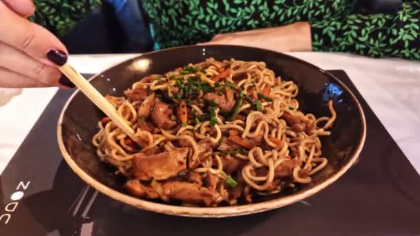 Woman hand eating Yaki Soba noodles with chopsticks — Stock Video