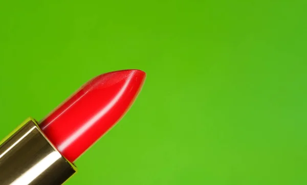 Beautiful bright red lipstick and green complementary color on the background — Stock Photo, Image