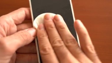Bakteri ya da koronavirüsten korunmak için e ile akıllı telefon ekranı temizleniyor.