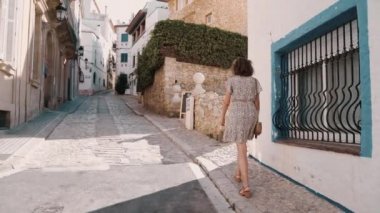 Akdeniz 'in fırında pişirilen Sitges köyünde güzel kıvırcık esmer turist.