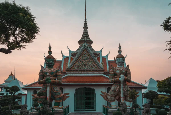 Um pavilhão com duas estátuas de thotsakhirithons a caminho do Wat Arun do cais . — Fotografia de Stock