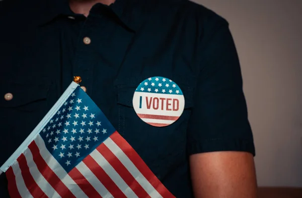 Hombre anónimo con pin de voto de campaña electoral y la bandera de EE.UU.. — Foto de Stock