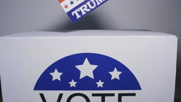 USA elections 2020, the hand of a man putting a vote for trump in a ballot box with the US Map and flag — Stock Video