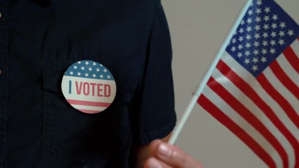 Anonym man med valkampanj röstnål och USA: s flagga hand. — Stockvideo