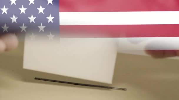 USA verkiezingen 2020, hand van een man die een stem uitbrengt met de Amerikaanse vlag op de achtergrond — Stockvideo