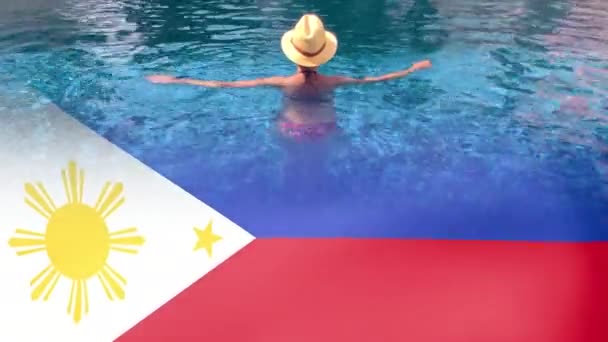 Filipińczycy machają flagą i kobieta z kapeluszem relaksującym się w basenie w kurorcie spa. — Wideo stockowe