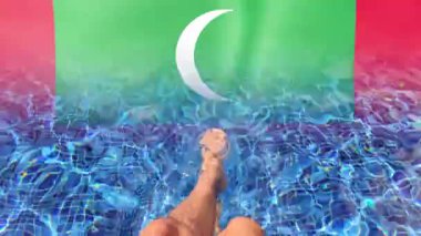 Maldivler bayrak sallıyor ve havuz kenarında dinlenen bacaklar.