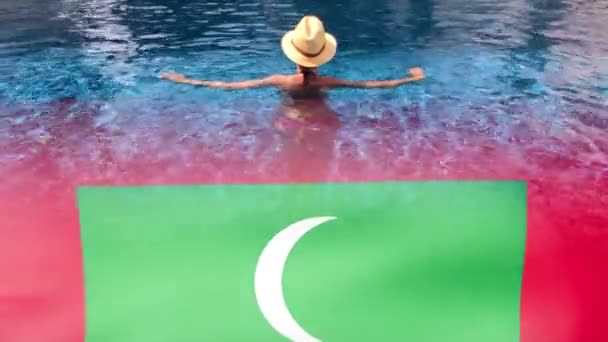Μαλδίβες κυματίζουν σημαία και γυναίκα με καπέλο χαλαρώνοντας στην πισίνα στο θέρετρο spa. — Αρχείο Βίντεο