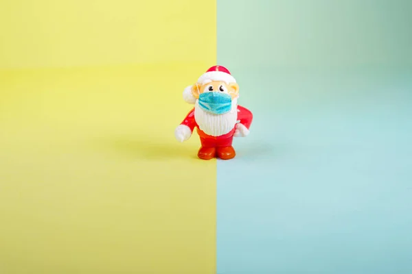 Spielzeugfigur Weihnachtsmann mit chirurgischer Gesichtsmaske. — Stockfoto